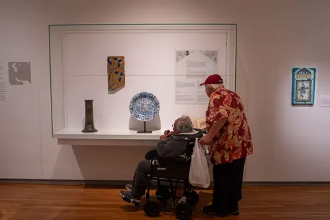 Two visitors share a quiet conversation inside an art museum.
